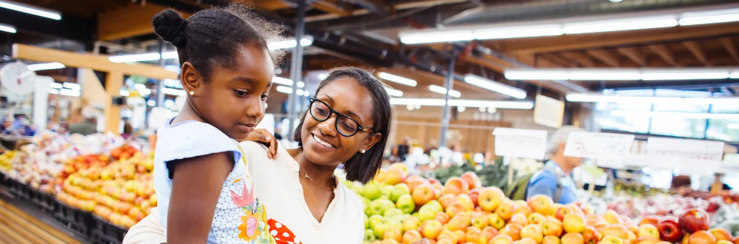 Mother and child in grocery store produce section