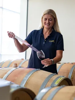 Anita sampling wine from barrel