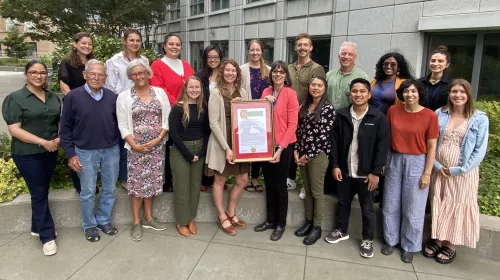 Nutrition Policy Institute team celebrates with a resolution recognizing their achievements